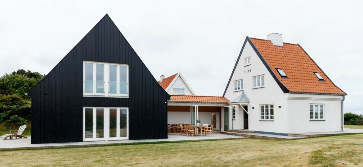 Bevaringsværdigt sommerhus med tilbygning blev totalrenoveret, hvidt Bedre Byggeskik-hus og sort tilbygning
