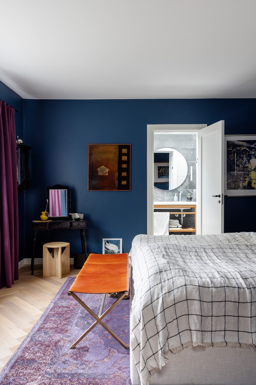 Farverigt soveværelse i smuk mørkeblå nuance, kig til badeværelse